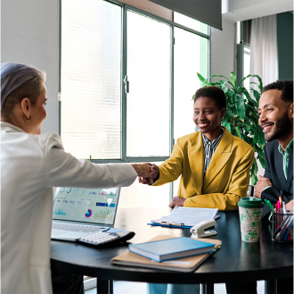 Advisor shakes hands with clients after reviewing Schwab Genesis Advisory Variable Annuity contract.