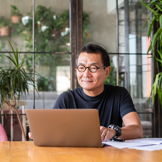 Man at laptop reviewing Protective ProPayer Income Annuity key product specs.