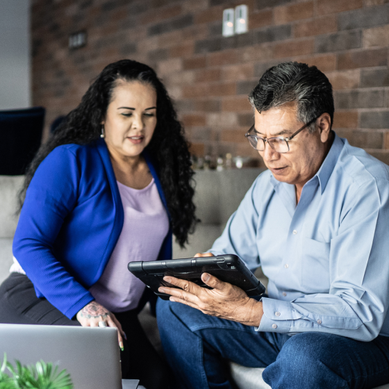 Financial advisor going over details of Schwab Genesis Advisory Variable Annuity on his mobile device with a prospective client.