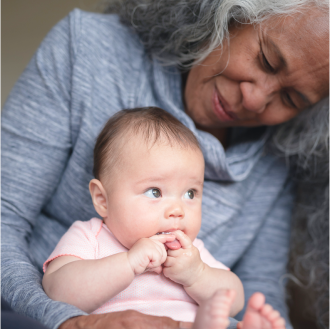 A grandmother holding her infant grandchild knowing her financial legacy is protected.
