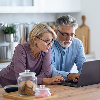 Couple in their kitchen using a laptop to learn more about Protective Indexed Annuity II.