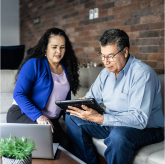 Financial advisor going over details of Schwab Genesis Variable Annuity on his mobile device with a prospective client.